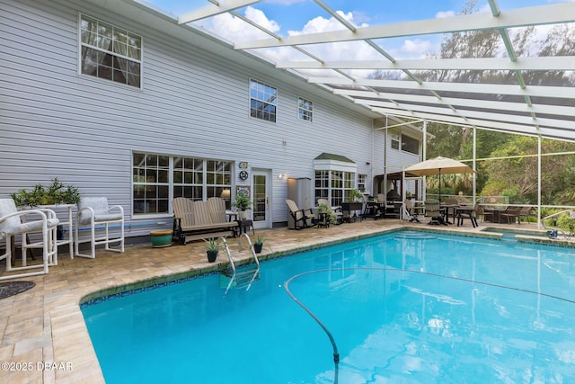 view of pool featuring glass enclosure and a patio