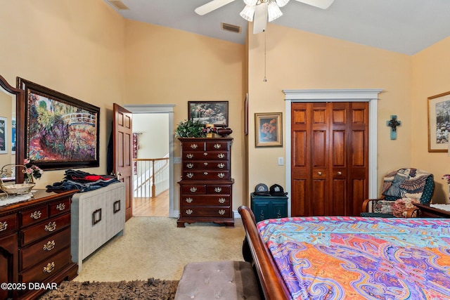 carpeted bedroom with ceiling fan, lofted ceiling, and a closet