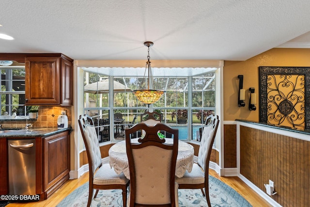 dining room with light hardwood / wood-style flooring and a textured ceiling