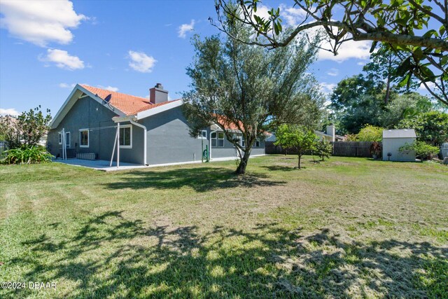 view of yard with a shed and a patio area