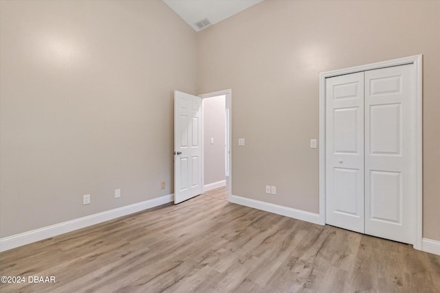 10 Falls Pl, Palm Coast, FL 32137 - unfurnished bedroom with high vaulted ceiling, wood finished floors, baseboards, and a closet