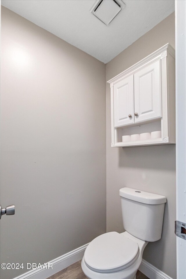 bathroom featuring hardwood / wood-style flooring and toilet