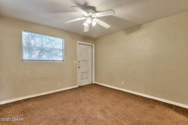 carpeted spare room with ceiling fan