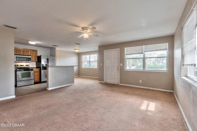 unfurnished living room with light colored carpet and ceiling fan