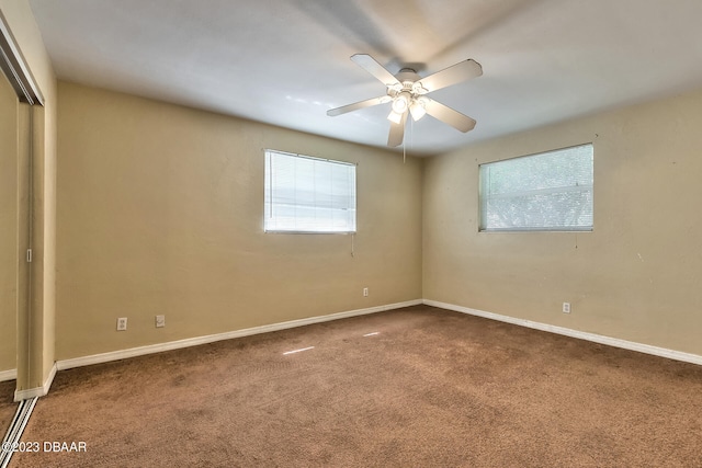 unfurnished bedroom featuring carpet flooring, multiple windows, and ceiling fan