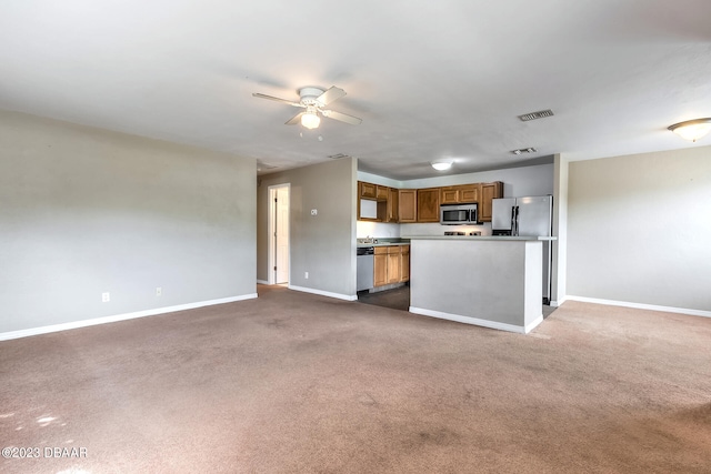 kitchen with a kitchen island, dark colored carpet, ceiling fan, and stainless steel appliances