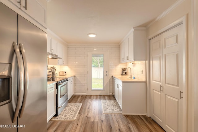 92 S Orchard St, Ormond Beach, FL 32174 - kitchen with stainless steel appliances, a sink, light countertops, under cabinet range hood, and backsplash