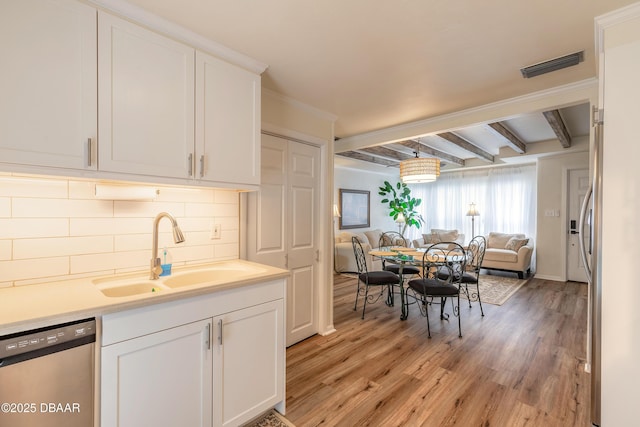 92 S Orchard St, Ormond Beach, FL 32174 - kitchen featuring stainless steel dishwasher, a sink, open floor plan, tasteful backsplash, and light wood-style flooring
