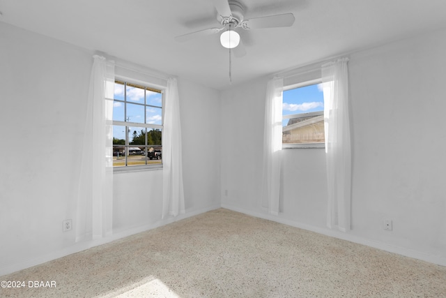 unfurnished room with ceiling fan and a healthy amount of sunlight