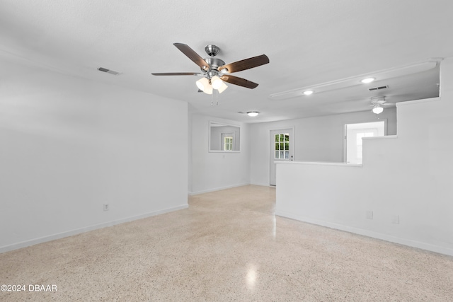 empty room with a textured ceiling and ceiling fan