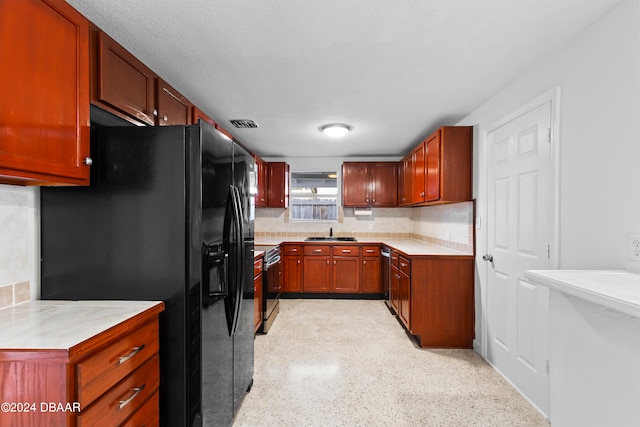 kitchen featuring black fridge, decorative backsplash, sink, and electric stove