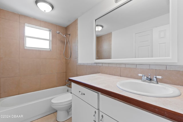 full bathroom featuring tile walls, tile patterned floors, vanity, tiled shower / bath combo, and toilet