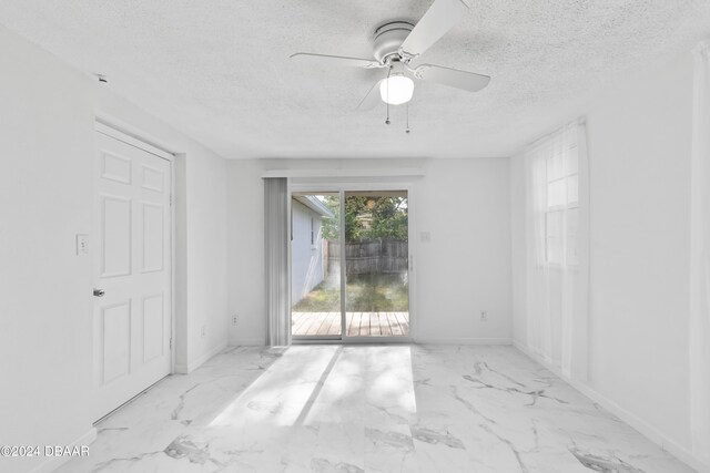 empty room with a textured ceiling and ceiling fan