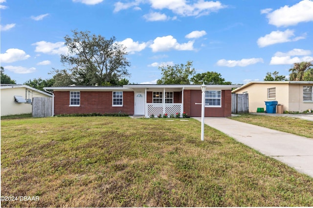 single story home with covered porch and a front lawn