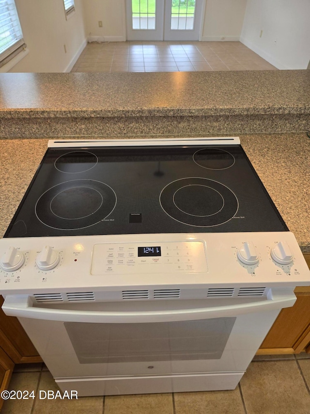 details featuring white stove and tile patterned flooring