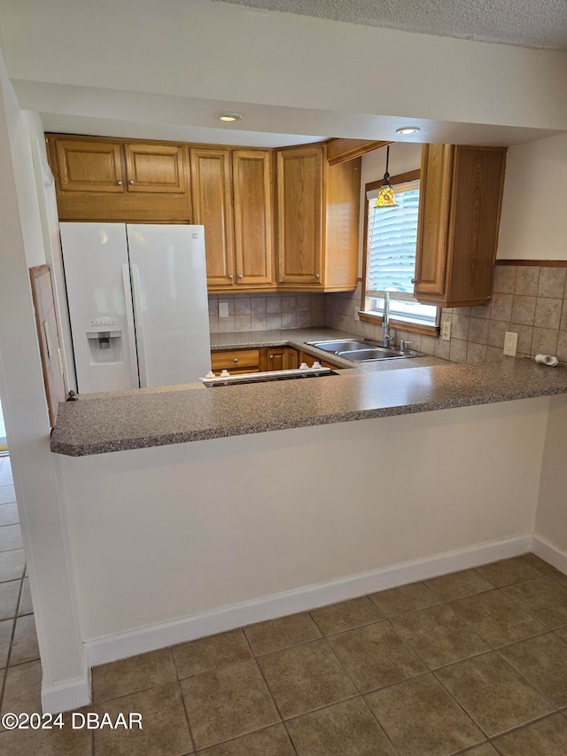 kitchen featuring sink, tasteful backsplash, white fridge with ice dispenser, tile patterned floors, and pendant lighting