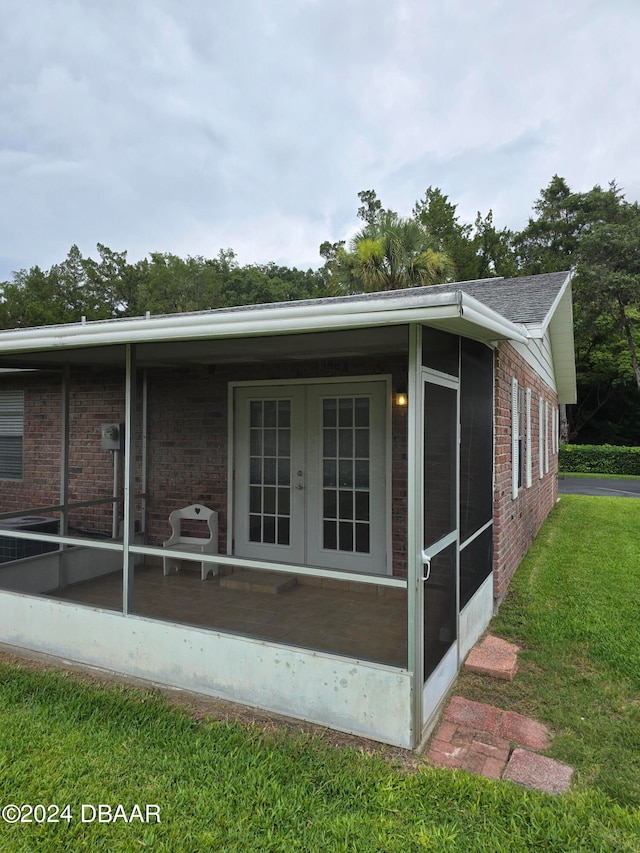 view of property exterior featuring a sunroom and a yard