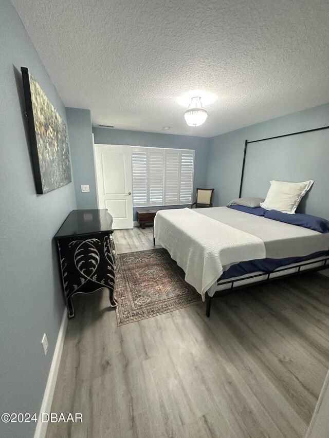 1021 Alabama Ave, Holly Hill, FL 32117 - bedroom featuring wood finished floors, a textured ceiling, and baseboards