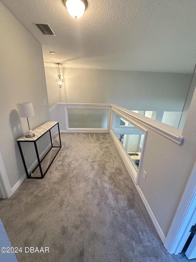 1021 Alabama Ave, Holly Hill, FL 32117 - corridor featuring a textured ceiling, carpet floors, baseboards, and an upstairs landing