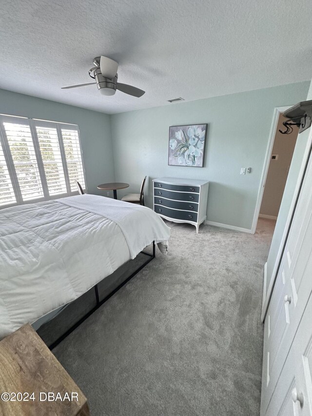 1021 Alabama Ave, Holly Hill, FL 32117 - bedroom featuring carpet flooring, a textured ceiling, baseboards, and a ceiling fan