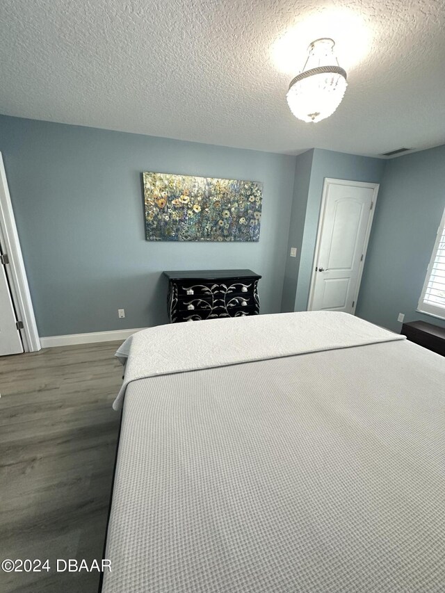 1021 Alabama Ave, Holly Hill, FL 32117 - bedroom featuring wood finished floors, baseboards, and a textured ceiling