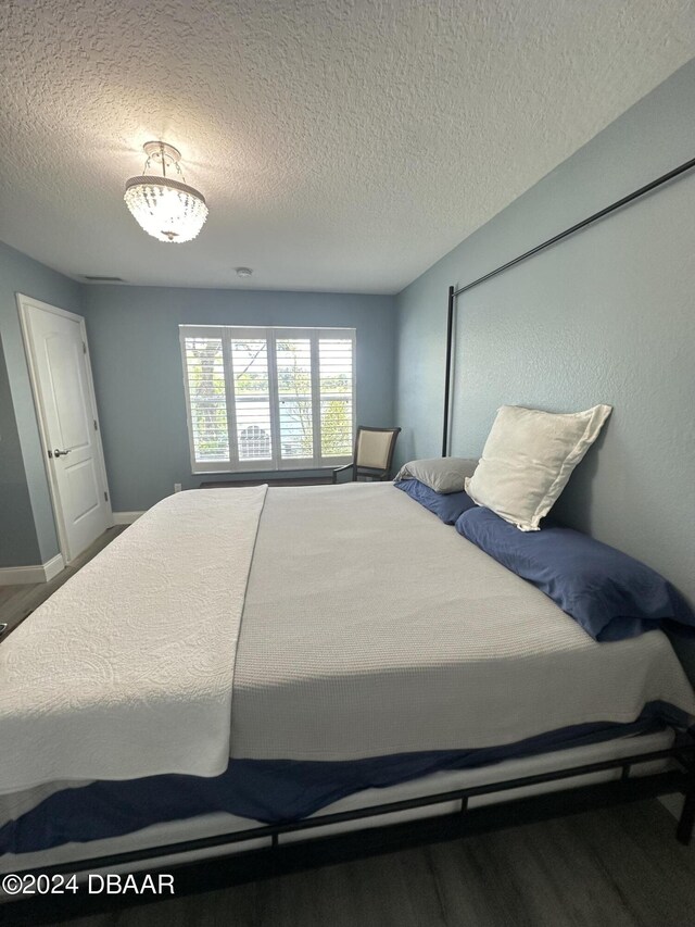 1021 Alabama Ave, Holly Hill, FL 32117 - bedroom featuring wood finished floors, a textured ceiling, and baseboards