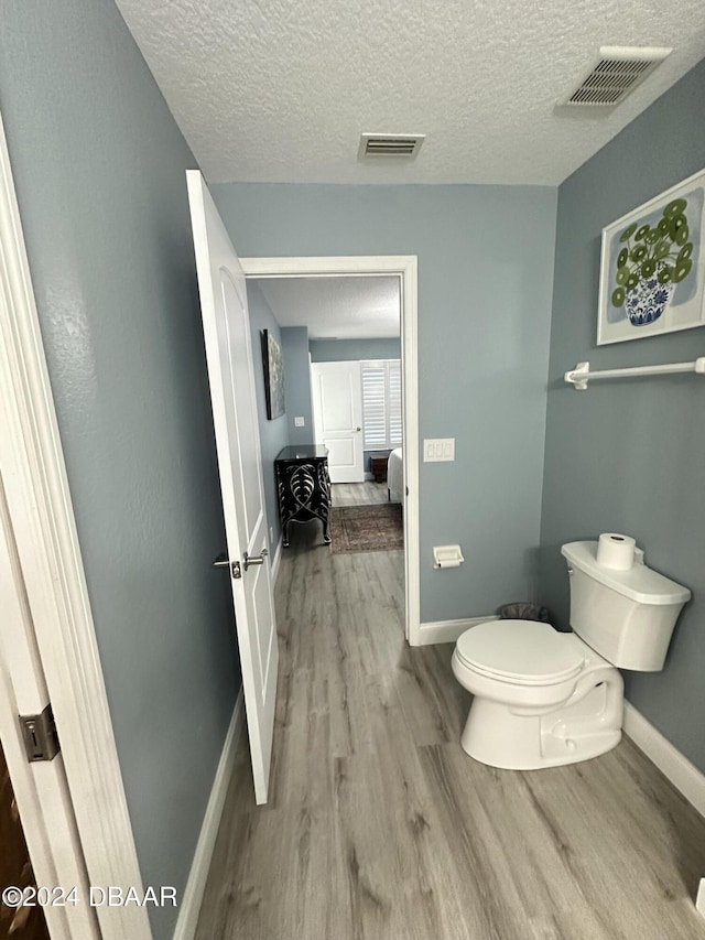 1021 Alabama Ave, Holly Hill, FL 32117 - bathroom featuring wood finished floors, toilet, baseboards, and a textured ceiling