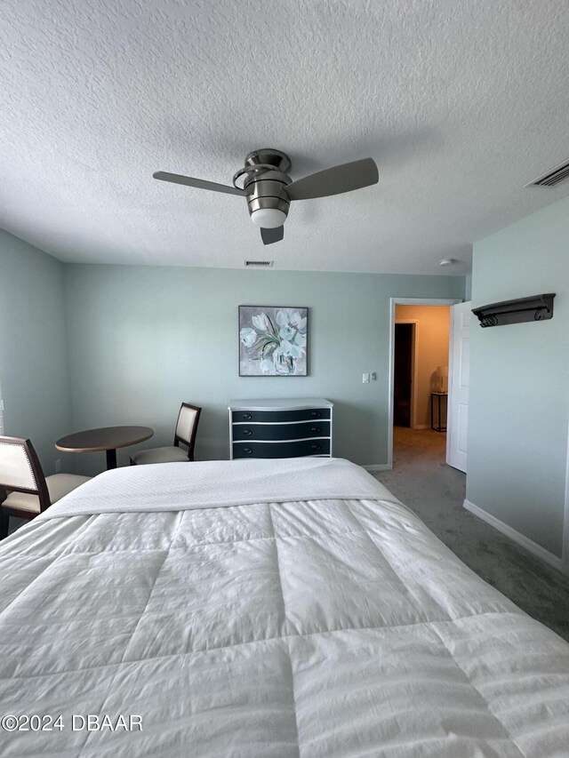 1021 Alabama Ave, Holly Hill, FL 32117 - bedroom with baseboards, carpet floors, a ceiling fan, and a textured ceiling