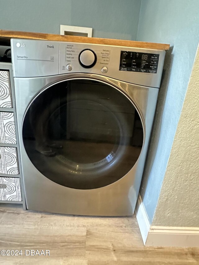 1021 Alabama Ave, Holly Hill, FL 32117 - washroom featuring washer / clothes dryer, wood finished floors, and a textured wall
