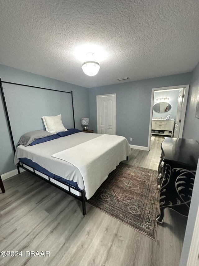1021 Alabama Ave, Holly Hill, FL 32117 - bedroom featuring wood finished floors, a textured ceiling, baseboards, and a closet