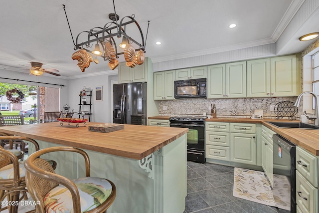 1409 Mollie Rd, Daytona Beach, FL 32114 - kitchen with wood counters, black appliances, green cabinetry, backsplash, and a breakfast bar area