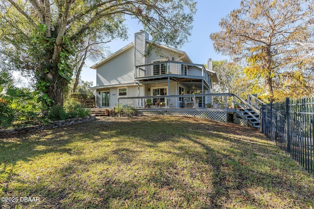 back of property featuring a wooden deck and a yard