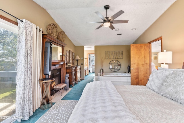 bedroom featuring ceiling fan, a textured ceiling, vaulted ceiling, a fireplace, and carpet