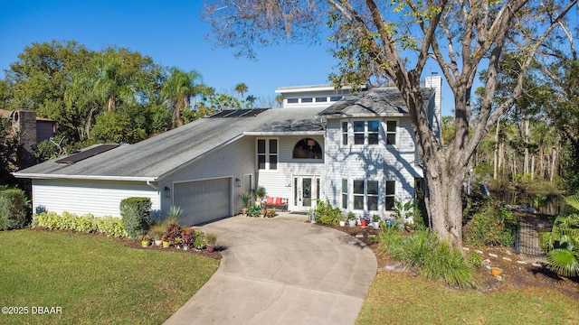 view of front of property with a garage and a front lawn