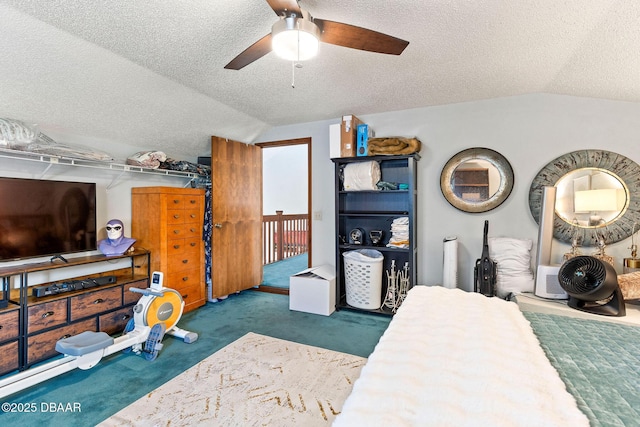 bedroom with a textured ceiling, ceiling fan, carpet floors, and vaulted ceiling