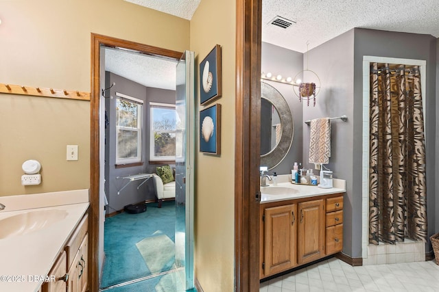 bathroom featuring a shower with shower curtain, vanity, and a textured ceiling