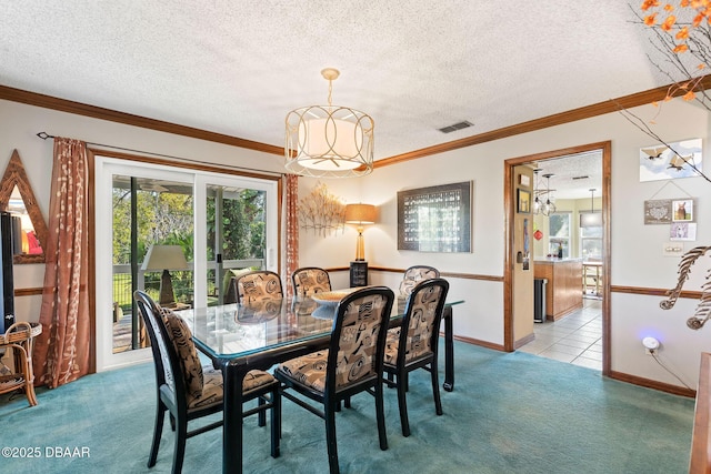 carpeted dining space featuring a textured ceiling and ornamental molding