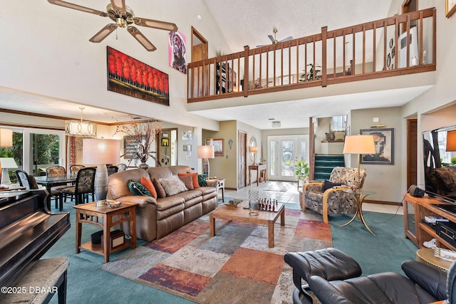 living room with ceiling fan with notable chandelier, a towering ceiling, and a healthy amount of sunlight