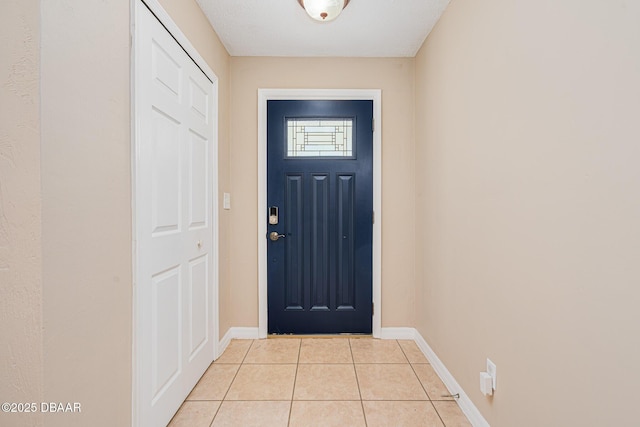 doorway to outside with light tile patterned flooring and baseboards