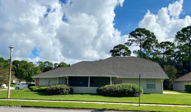 single story home with a sunroom and a front yard