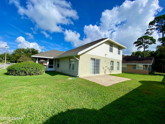 back of house with a lawn and a patio