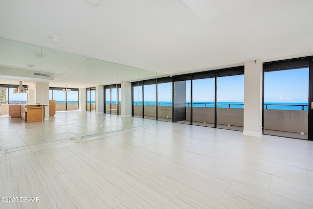 empty room with a notable chandelier and a water view