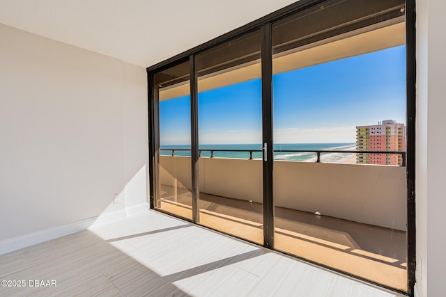 unfurnished room with a view of the beach and a water view