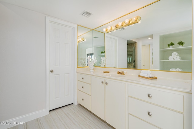 bathroom featuring an enclosed shower, vanity, and built in shelves