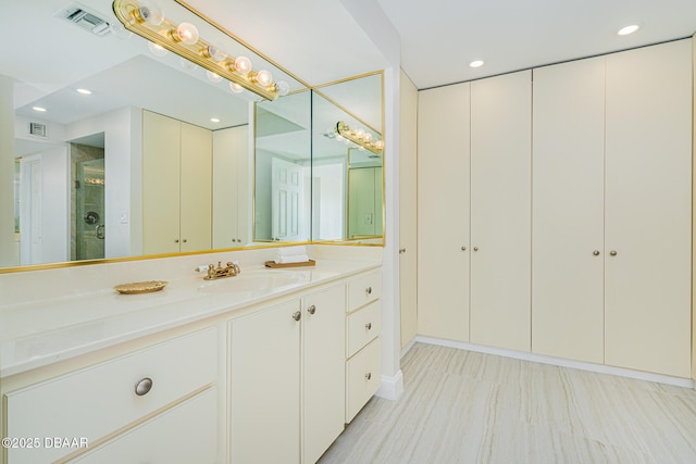 bathroom with vanity and a shower with door