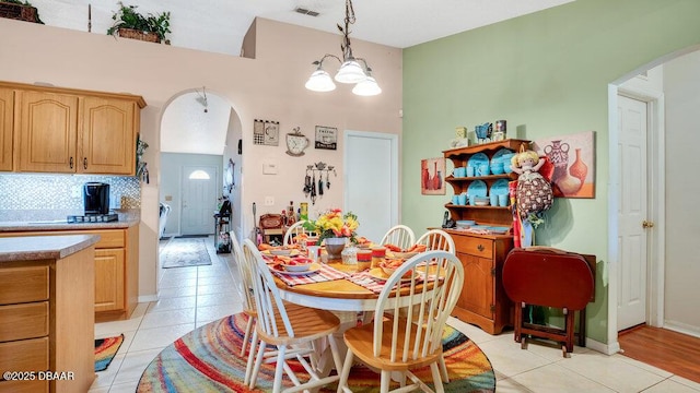 dining space featuring light tile patterned floors and a chandelier