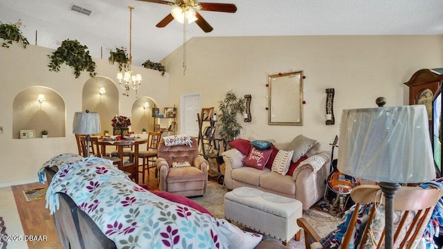 living room featuring ceiling fan with notable chandelier and lofted ceiling