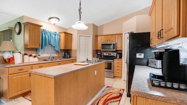 kitchen with appliances with stainless steel finishes, decorative light fixtures, sink, a kitchen island with sink, and light tile patterned floors