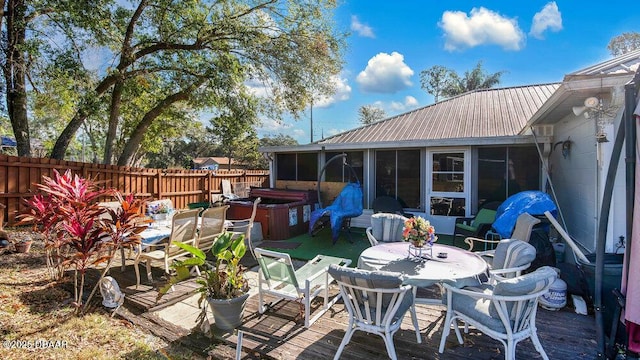 view of patio / terrace with a sunroom and a hot tub