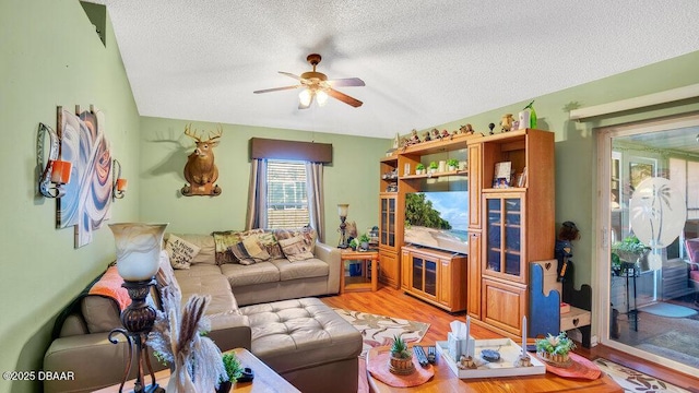 living room featuring ceiling fan, a textured ceiling, and light hardwood / wood-style flooring